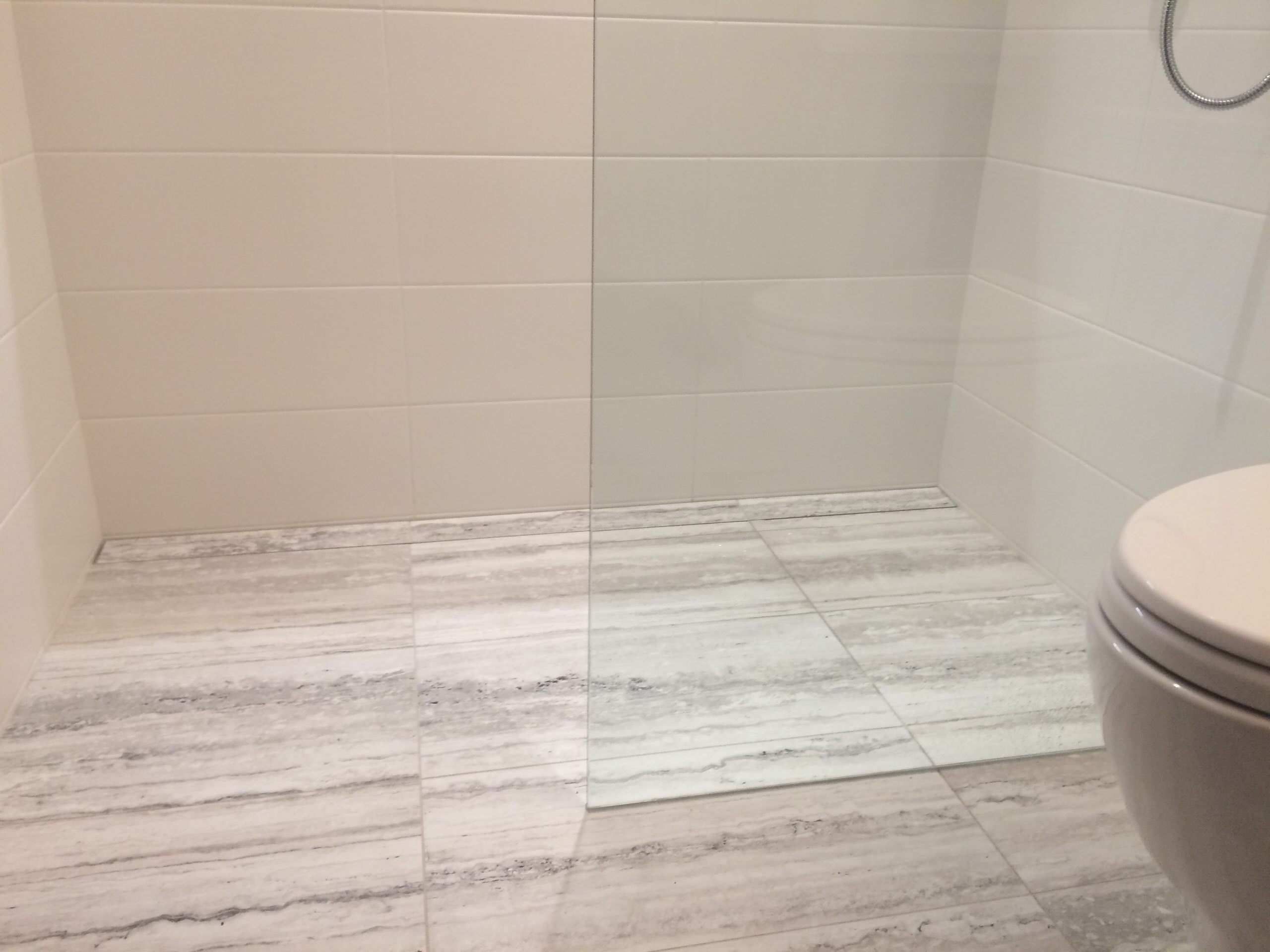 Curb-less walking shower featuring linear drain