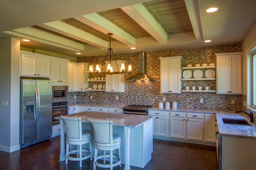 Inspiration for a mid-sized transitional u-shaped dark wood floor and brown floor open concept kitchen remodel in Cincinnati with a double-bowl sink, shaker cabinets, white cabinets, granite countertops, multicolored backsplash, matchstick tile backsplash, stainless steel appliances and an island