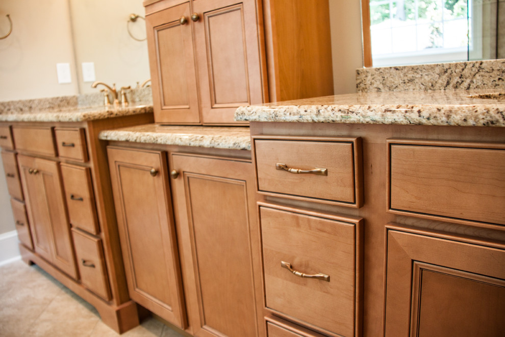 Mid-sized traditional master bathroom in Other with an undermount sink, medium wood cabinets, granite benchtops, a drop-in tub, a corner shower, a two-piece toilet, beige tile, ceramic tile, beige walls, ceramic floors and recessed-panel cabinets.