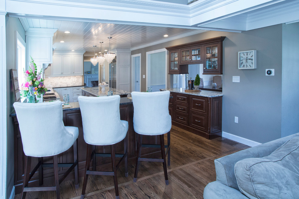 Expansive transitional u-shaped open plan kitchen in Boston with an undermount sink, beaded inset cabinets, white cabinets, granite benchtops, white splashback, mosaic tile splashback, stainless steel appliances, dark hardwood floors and with island.