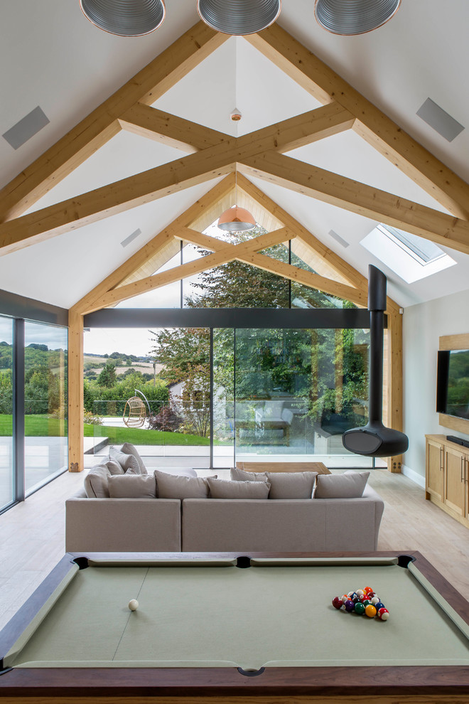 This is an example of a contemporary family room in Buckinghamshire with a hanging fireplace.