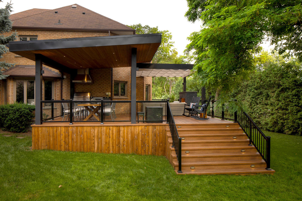 Inspiration for a modern backyard deck in Toronto with with fireplace and a pergola.