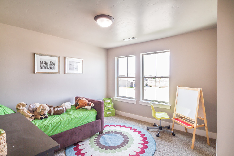 Photo of a traditional gender-neutral kids' room for kids 4-10 years old in Boise with beige walls and carpet.
