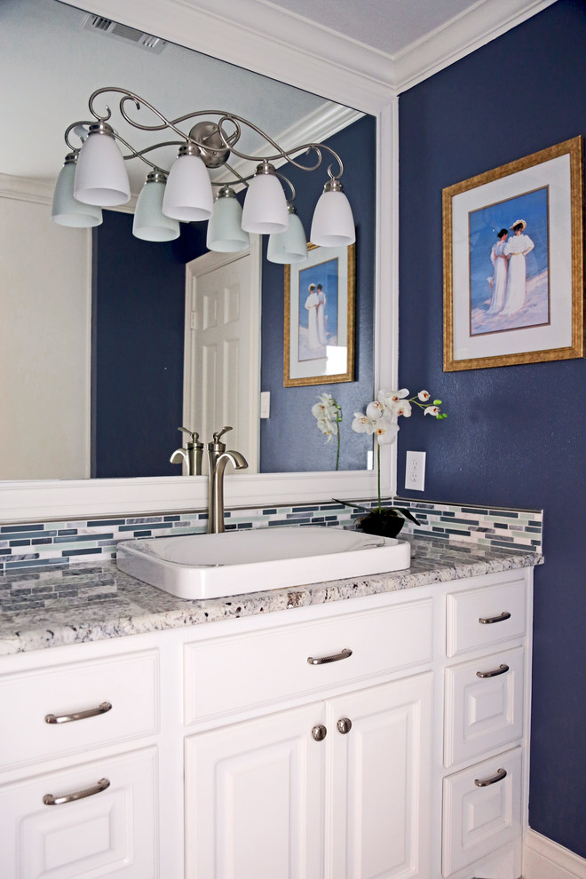 This is an example of a small traditional 3/4 bathroom in Other with raised-panel cabinets, white cabinets, blue tile, mosaic tile, blue walls, a pedestal sink, granite benchtops, multi-coloured benchtops, a single vanity and a built-in vanity.