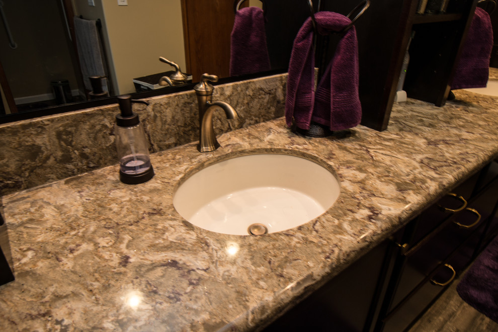 Photo of a mid-sized transitional master bathroom in Other with flat-panel cabinets, dark wood cabinets, an open shower, a two-piece toilet, beige tile, porcelain tile, beige walls, vinyl floors, an undermount sink and engineered quartz benchtops.