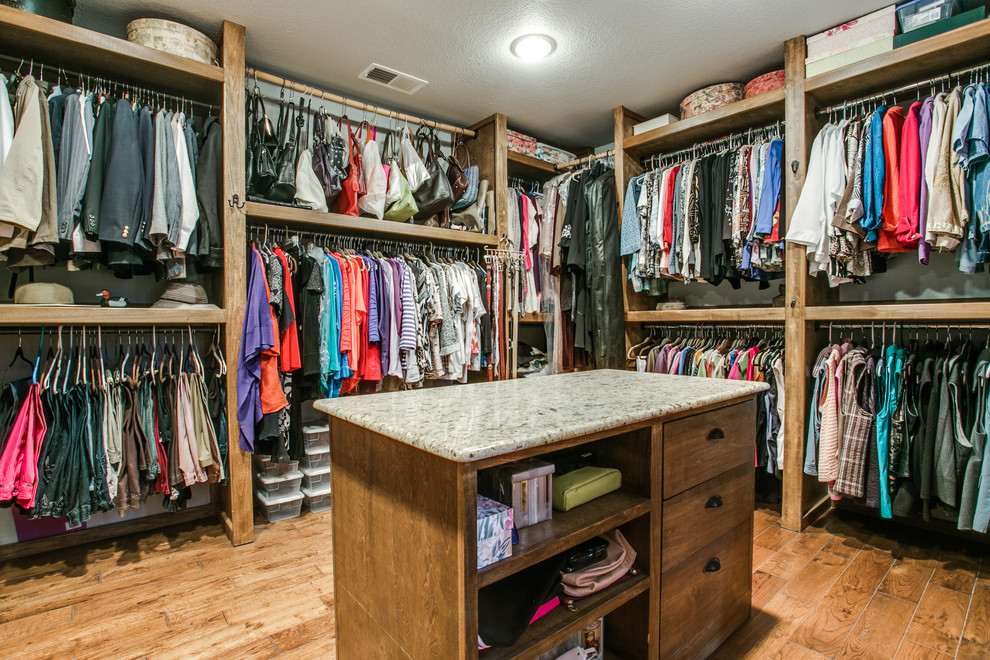 This is an example of a large modern men's walk-in wardrobe in Dallas with medium wood cabinets and medium hardwood floors.