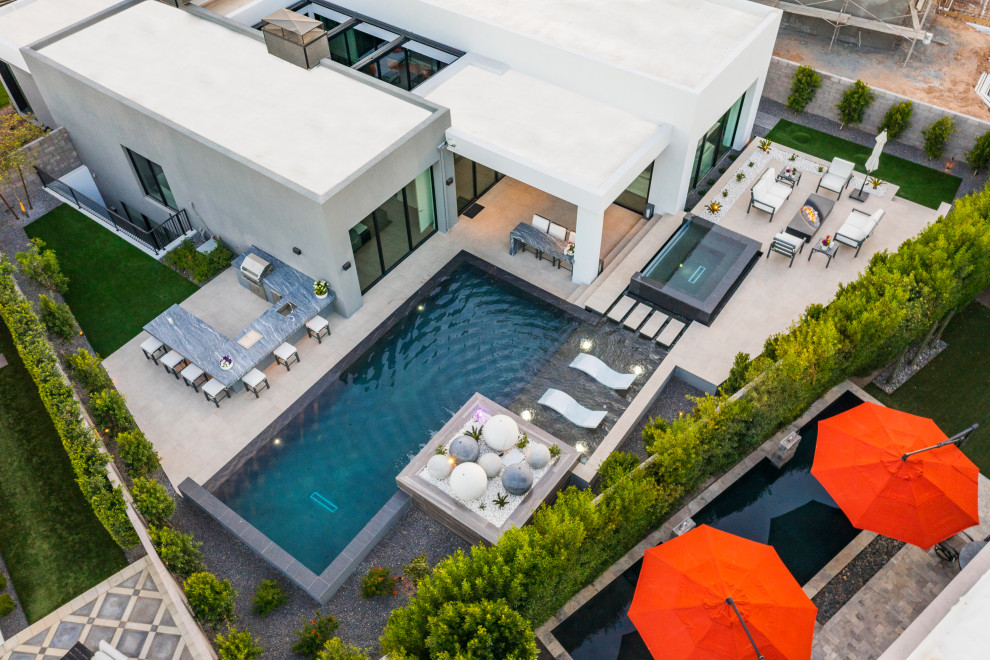 Pool landscaping - mid-sized modern backyard tile and rectangular infinity pool landscaping idea in Phoenix