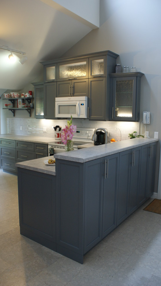 This is an example of a transitional l-shaped kitchen in Other with a double-bowl sink, recessed-panel cabinets, grey cabinets, laminate benchtops, white splashback, glass tile splashback, white appliances, marble floors and a peninsula.