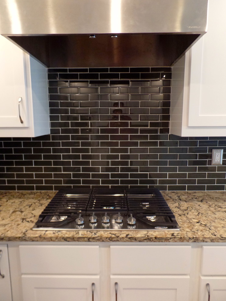 Inspiration for a large transitional u-shaped porcelain tile eat-in kitchen remodel with an undermount sink, shaker cabinets, white cabinets, quartz countertops, green backsplash, glass tile backsplash, stainless steel appliances and a peninsula