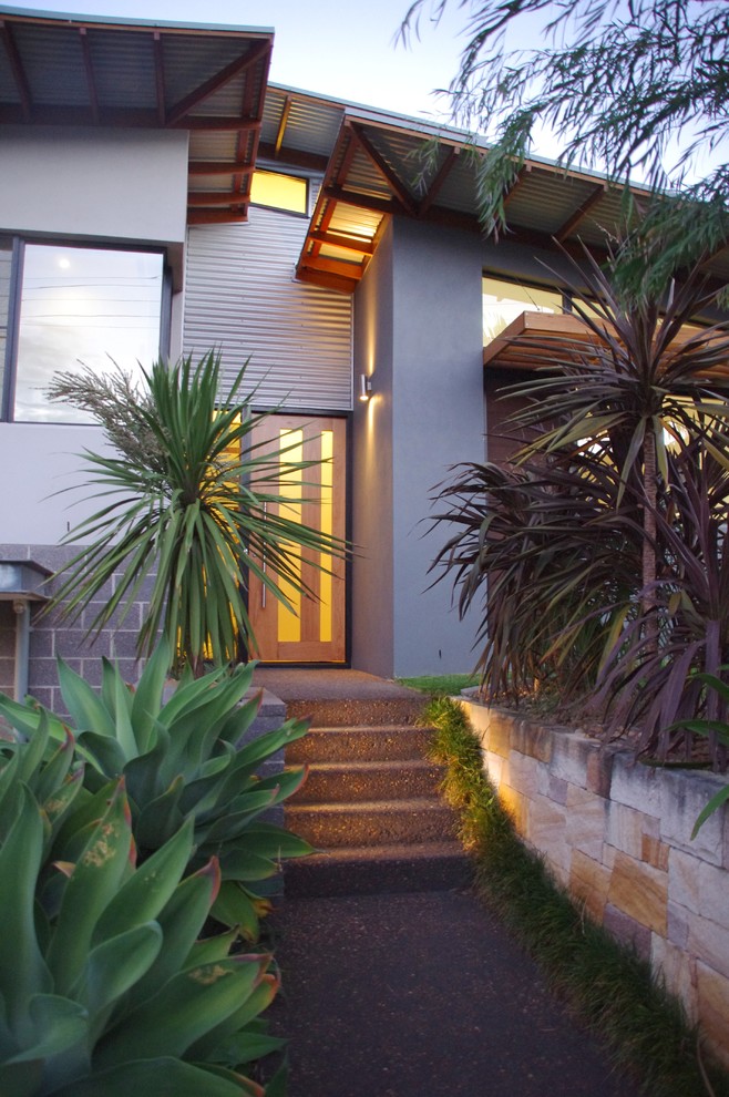 This is an example of a mid-sized contemporary split-level brick grey exterior in Central Coast.