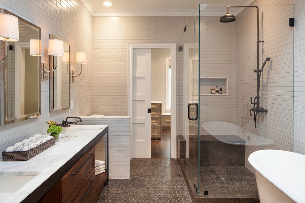 This is an example of a transitional master bathroom in New York with recessed-panel cabinets, dark wood cabinets, a freestanding tub, a corner shower, beige tile, subway tile, beige walls, mosaic tile floors, an undermount sink and a hinged shower door.