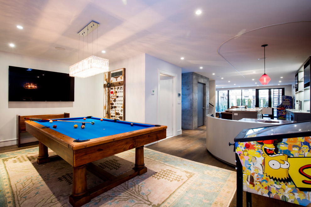 Photo of a large eclectic open concept family room in New York with a game room, white walls, dark hardwood floors and brown floor.