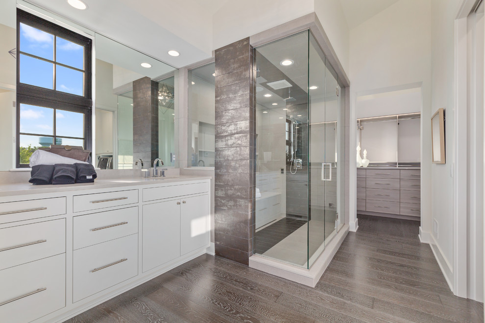 Design ideas for a contemporary master bathroom in Minneapolis with flat-panel cabinets, white cabinets, a double shower, white tile, porcelain tile, dark hardwood floors, an undermount sink, brown floor, a hinged shower door and beige benchtops.
