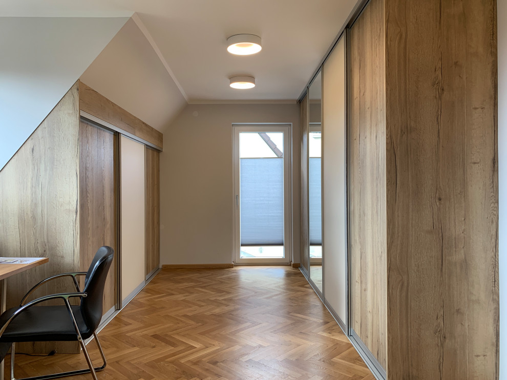 Foto di un grande spazio per vestirsi unisex design con parquet chiaro e pavimento marrone