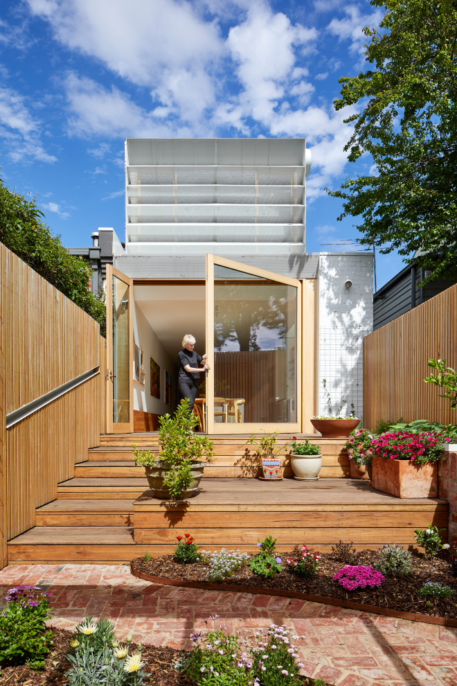 Immagine della facciata di una casa bianca contemporanea a due piani di medie dimensioni con rivestimento in mattone verniciato, tetto a capanna, copertura in metallo o lamiera e tetto bianco