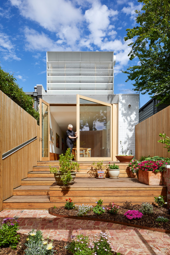 Zweistöckiges, Mittelgroßes Modernes Containerhaus mit gestrichenen Ziegeln, weißer Fassadenfarbe, Satteldach, Blechdach und weißem Dach in Melbourne