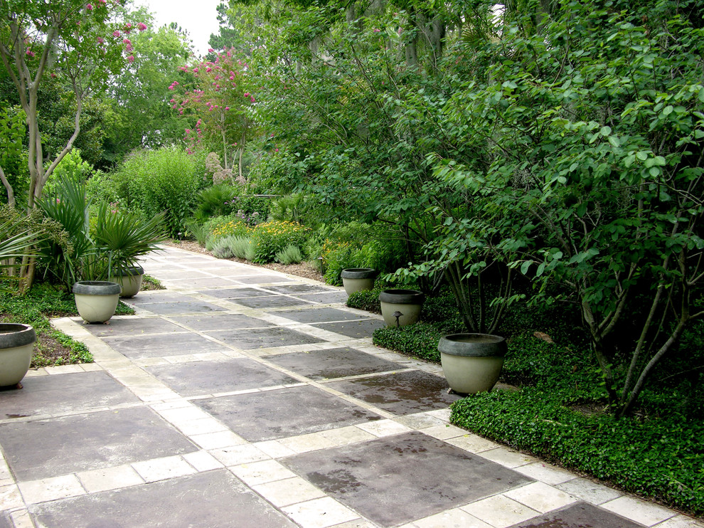 Photo of a mid-sized traditional courtyard partial sun garden in Other with a garden path and concrete pavers.