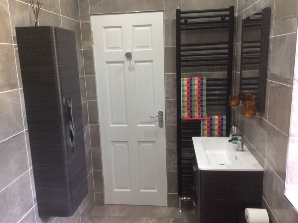 This is an example of a medium sized bathroom in Other with a built-in bath, a shower/bath combination, grey tiles and grey walls.
