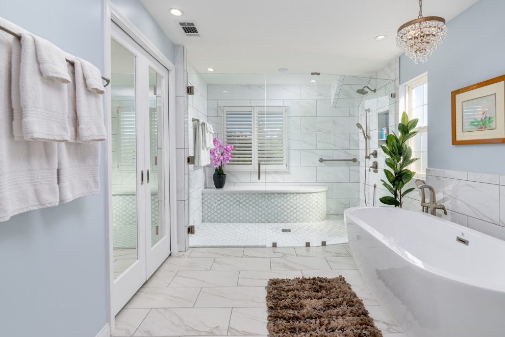 Inspiration for a large classic ensuite bathroom in Hawaii with light wood cabinets, a freestanding bath, a bidet, blue tiles, porcelain tiles, grey walls, porcelain flooring, a submerged sink, engineered stone worktops, white floors, a hinged door, white worktops, a shower bench, double sinks, a built in vanity unit and a drop ceiling.