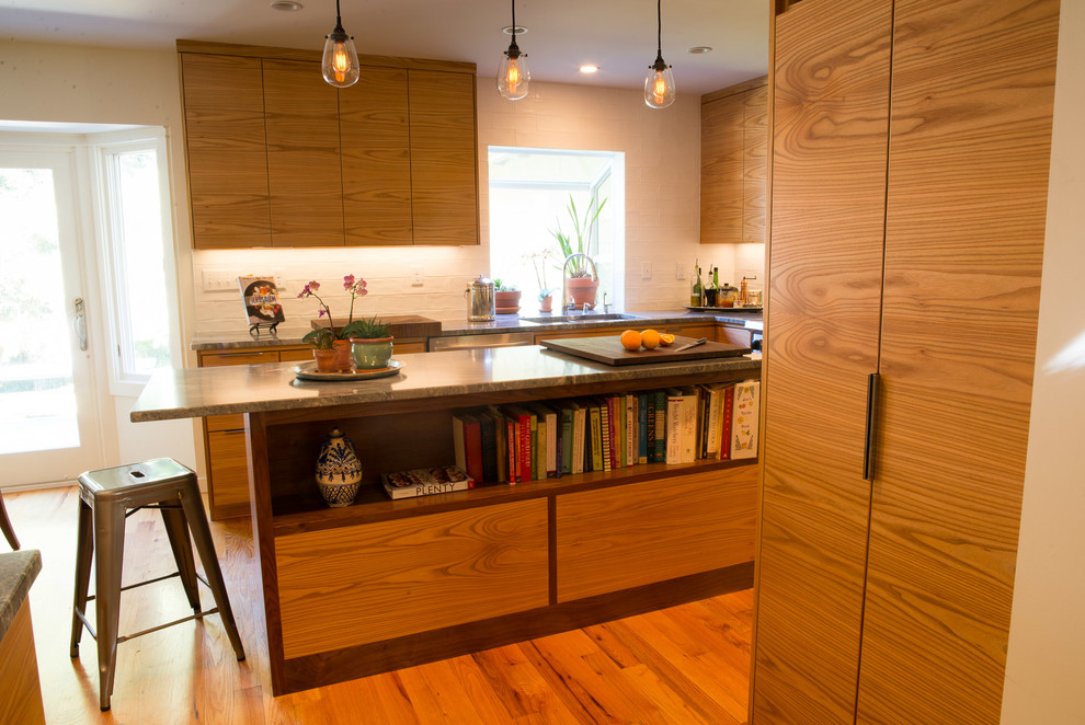 Eat-in kitchen - mid-sized transitional u-shaped medium tone wood floor eat-in kitchen idea with an undermount sink, flat-panel cabinets, medium tone wood cabinets, quartzite countertops, white backsplash, ceramic backsplash, stainless steel appliances and an island