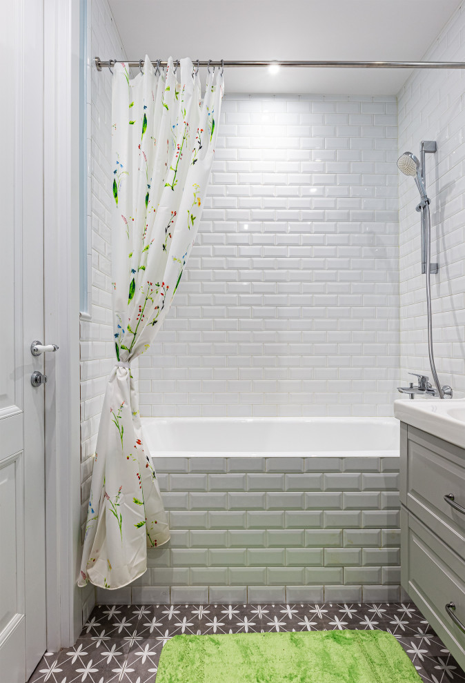 Стильный дизайн: маленькая главная ванная комната: освещение в стиле ретро с фасадами с выступающей филенкой, серыми фасадами, полновстраиваемой ванной, инсталляцией, белой плиткой, плиткой кабанчик, зелеными стенами, паркетным полом среднего тона, накладной раковиной, коричневым полом, тумбой под одну раковину, подвесной тумбой и обоями на стенах для на участке и в саду - последний тренд