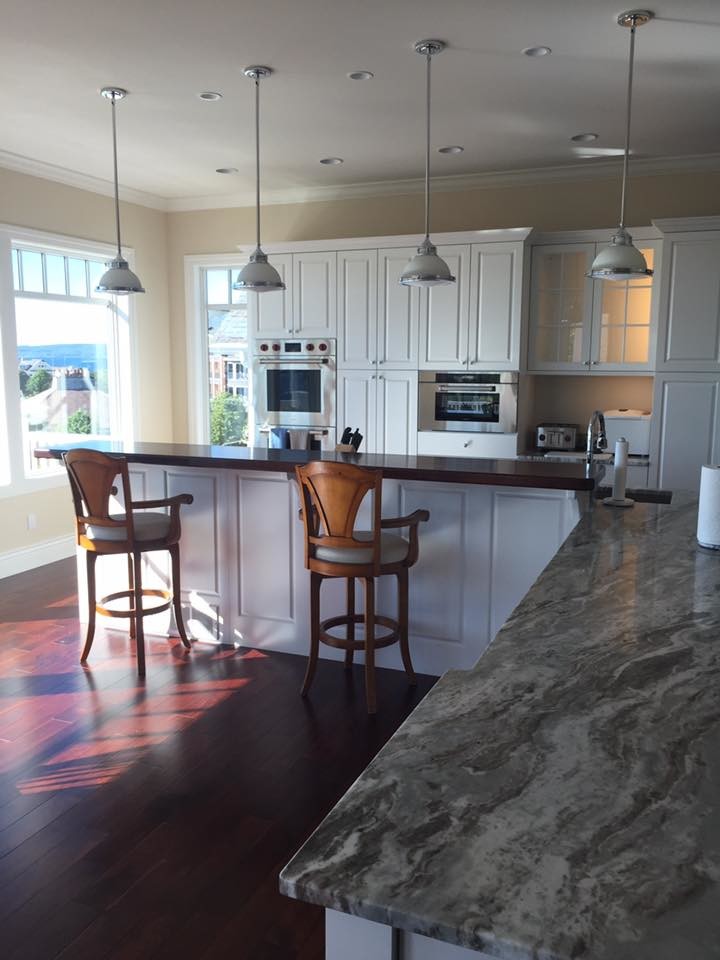 Example of a mid-sized transitional l-shaped dark wood floor and brown floor open concept kitchen design with an undermount sink, raised-panel cabinets, white cabinets, granite countertops, stainless steel appliances and an island