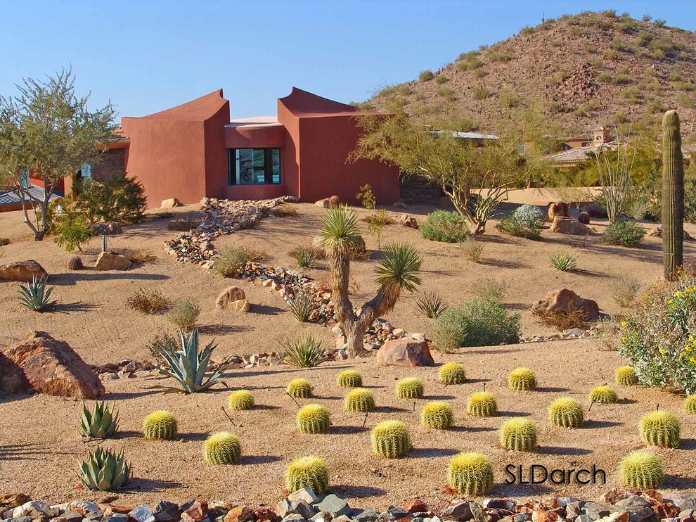 This is an example of a small contemporary two-storey stucco orange house exterior in Phoenix with a flat roof and a green roof.