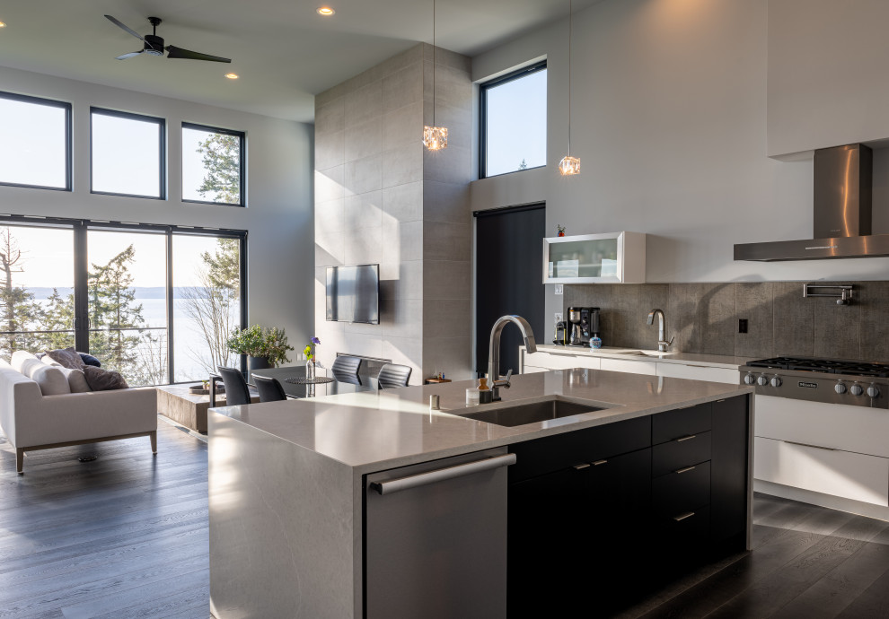 Design ideas for a mid-sized modern l-shaped kitchen in Seattle with an undermount sink, glass-front cabinets, white cabinets, quartzite benchtops, grey splashback, porcelain splashback, stainless steel appliances, porcelain floors, with island, brown floor and white benchtop.