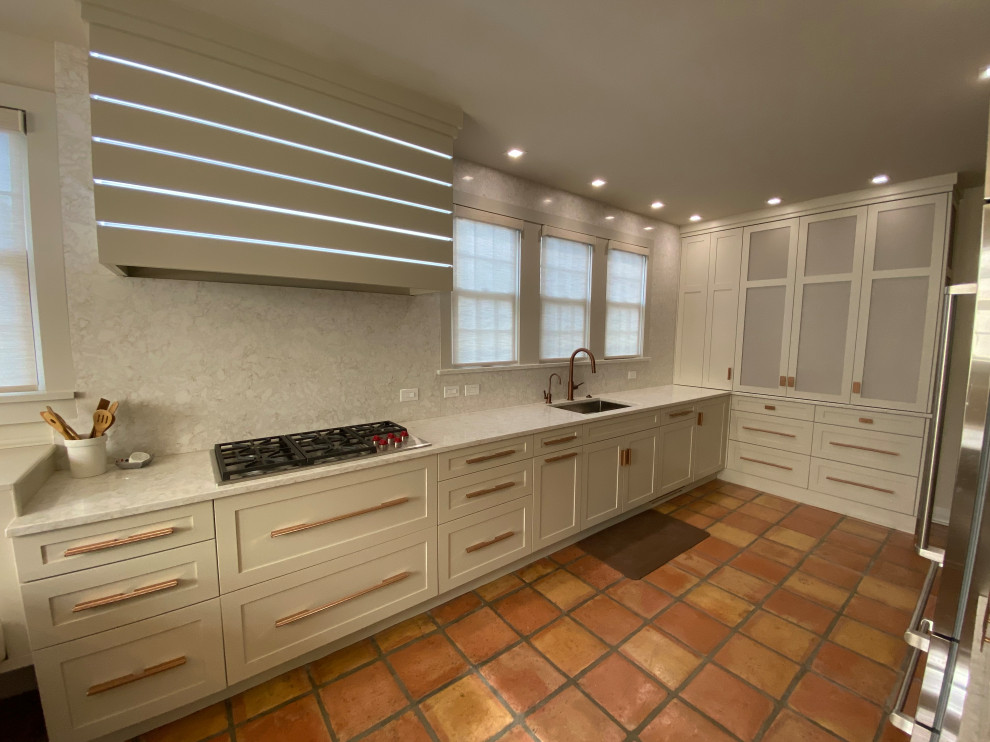 Example of a large beach style galley terra-cotta tile kitchen design in Philadelphia with an undermount sink, shaker cabinets, white cabinets, quartz countertops, quartz backsplash and stainless steel appliances