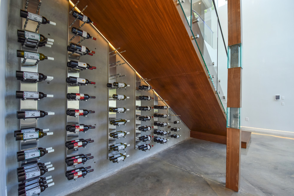 Inspiration for a modern wine cellar in Miami with concrete floors, storage racks and grey floor.