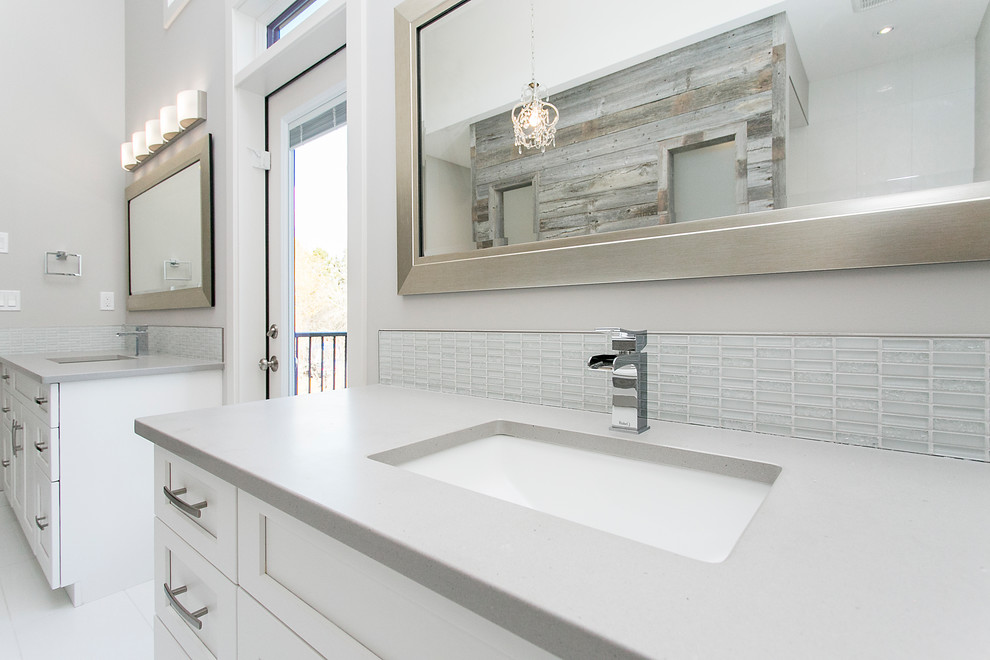 Inspiration for a mid-sized contemporary bathroom in Calgary with shaker cabinets, an alcove tub, a shower/bathtub combo, a one-piece toilet, glass tile, medium hardwood floors, an undermount sink and solid surface benchtops.