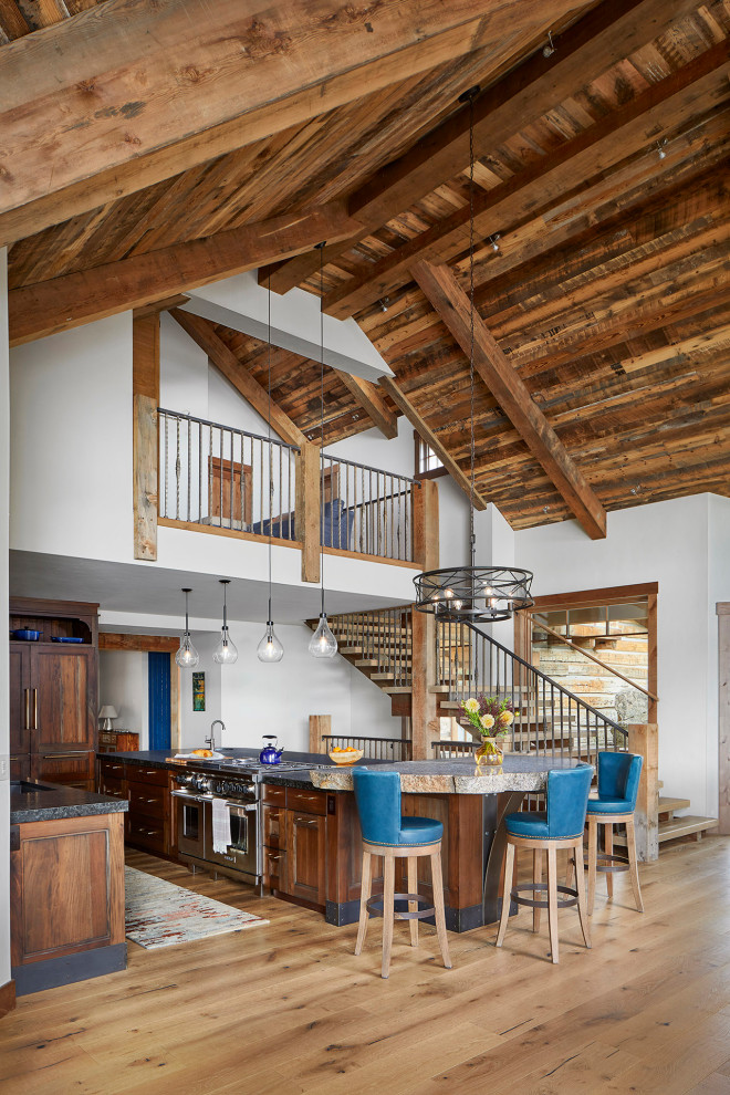Große Urige Küche in L-Form mit Granit-Arbeitsplatte, Küchengeräten aus Edelstahl, braunem Holzboden und Halbinsel in Denver