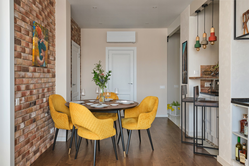 Esempio di una sala da pranzo aperta verso il soggiorno industriale di medie dimensioni con pareti beige, parquet scuro, pavimento marrone e pareti in mattoni
