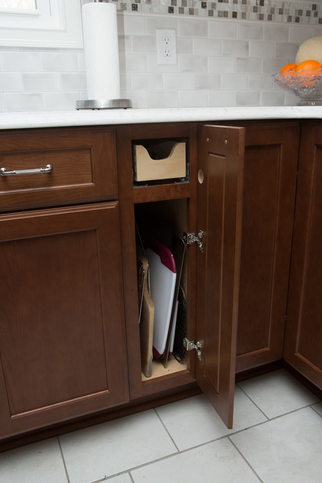 Inspiration for a mid-sized transitional l-shaped white floor and ceramic tile eat-in kitchen remodel with quartz countertops, white countertops, an undermount sink, shaker cabinets, medium tone wood cabinets, white backsplash, porcelain backsplash, stainless steel appliances and a peninsula