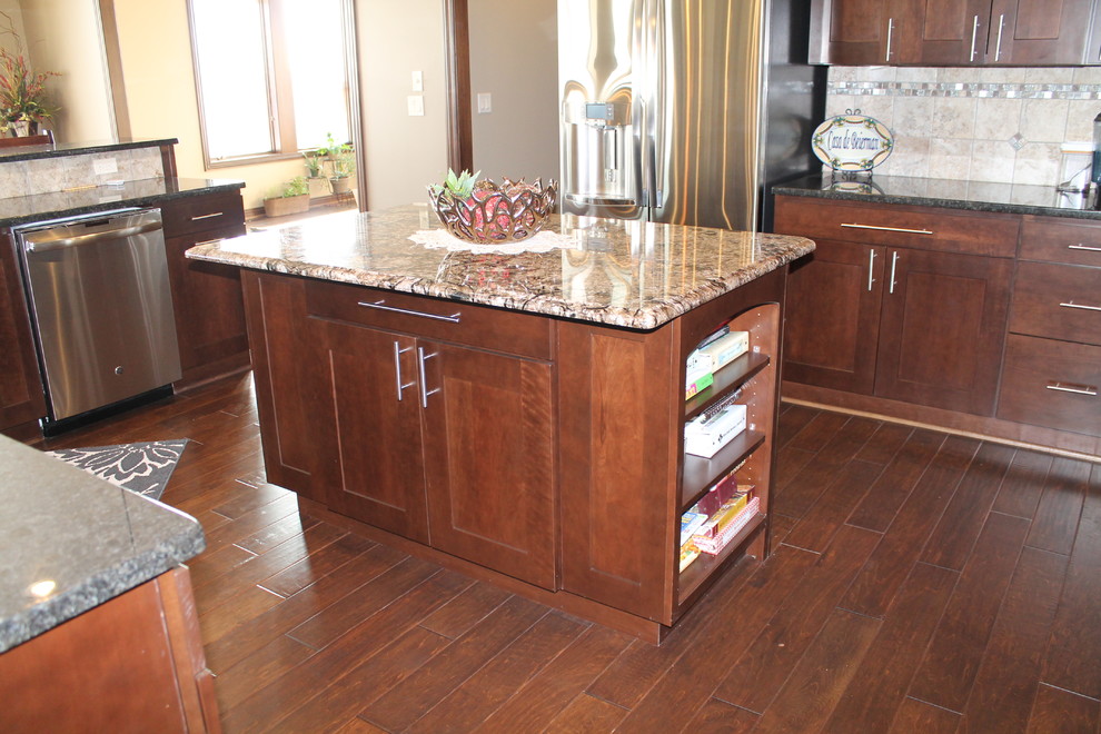 Inspiration for a large single-wall dark wood floor open concept kitchen remodel with an undermount sink, flat-panel cabinets, dark wood cabinets, granite countertops, beige backsplash, stainless steel appliances, beige walls and two islands