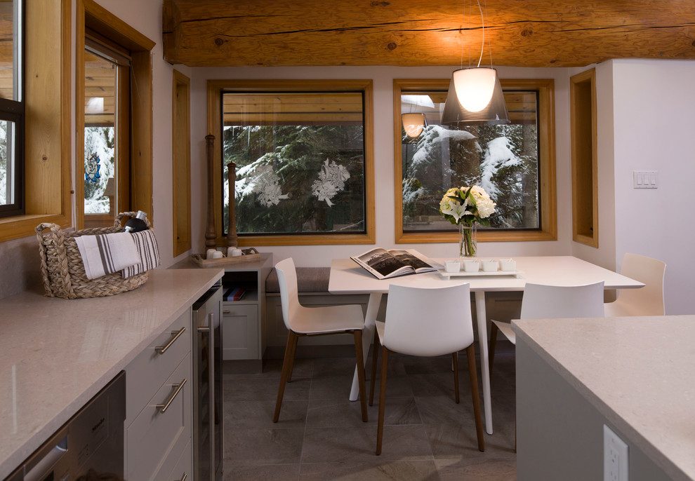 This is an example of a mid-sized transitional kitchen/dining combo in Vancouver with white walls and ceramic floors.