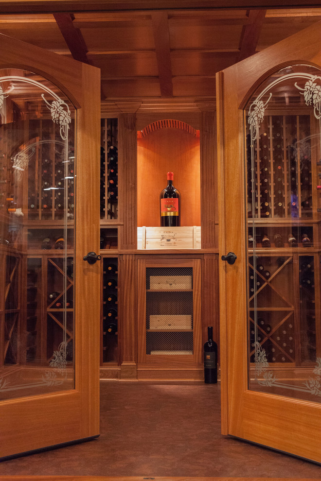 Large traditional wine cellar in Boston with cork floors, diamond bins and brown floor.
