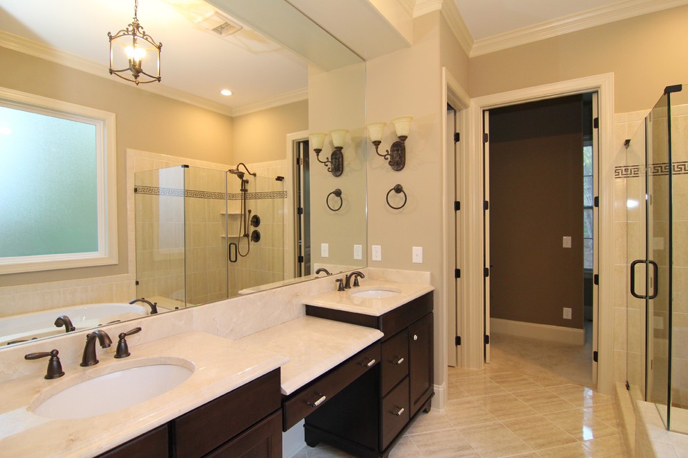 This is an example of a large traditional master bathroom in Raleigh with furniture-like cabinets, dark wood cabinets, a corner tub, a corner shower, a one-piece toilet, beige tile, ceramic tile, beige walls, ceramic floors, granite benchtops and an undermount sink.