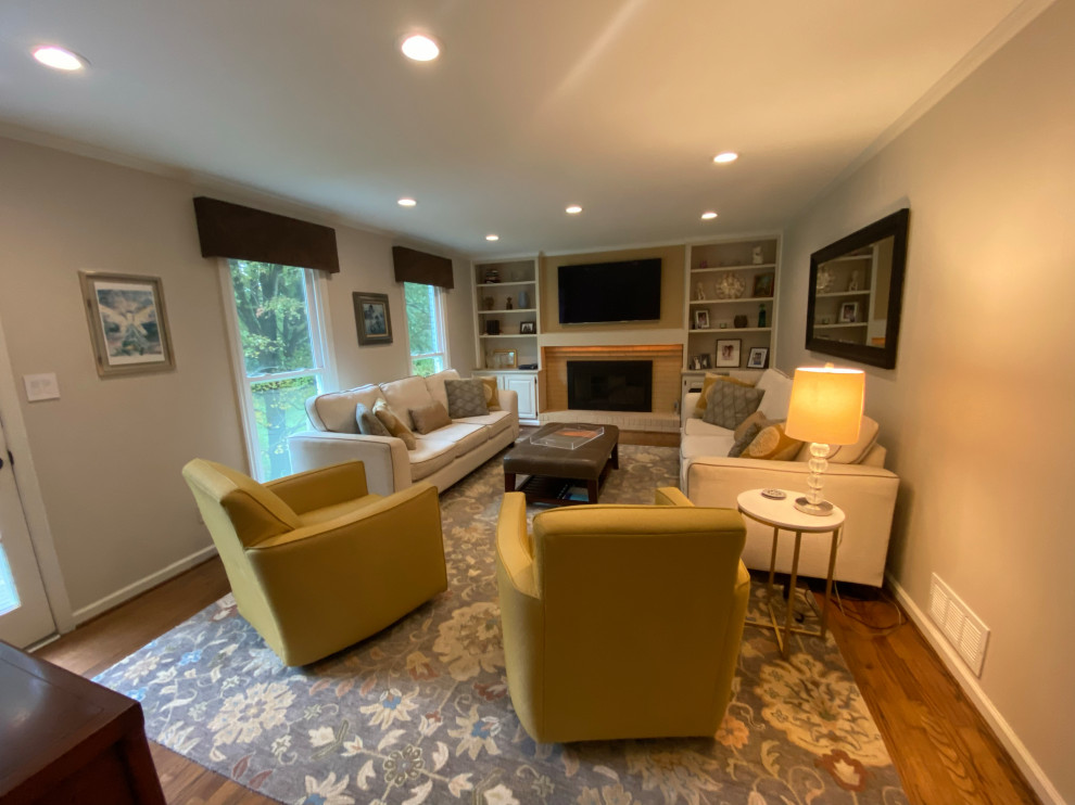 Mittelgroßes, Abgetrenntes Klassisches Wohnzimmer mit beiger Wandfarbe, braunem Holzboden, Kamin, Kaminumrandung aus Backstein und TV-Wand in Atlanta
