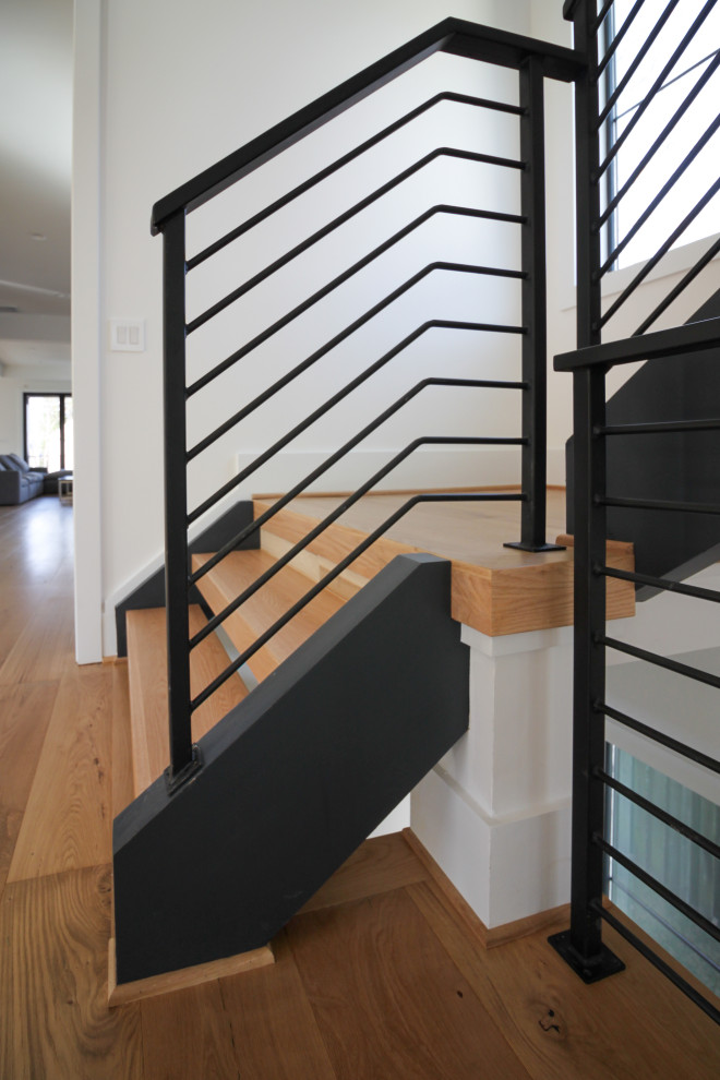 Свежая идея для дизайна: прямая лестница среднего размера в современном стиле с деревянными ступенями и металлическими перилами - отличное фото интерьера