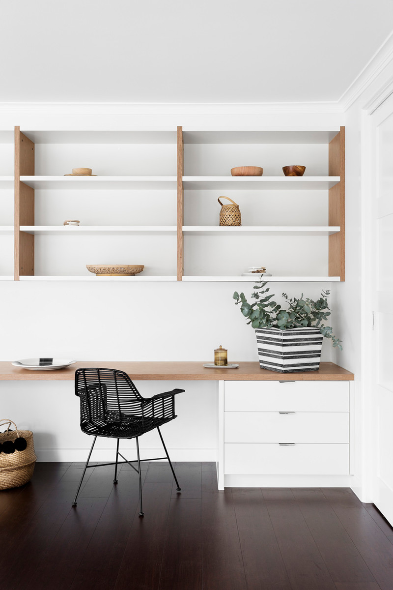This is an example of a mid-sized scandinavian study room in Melbourne with white walls, dark hardwood floors and a built-in desk.