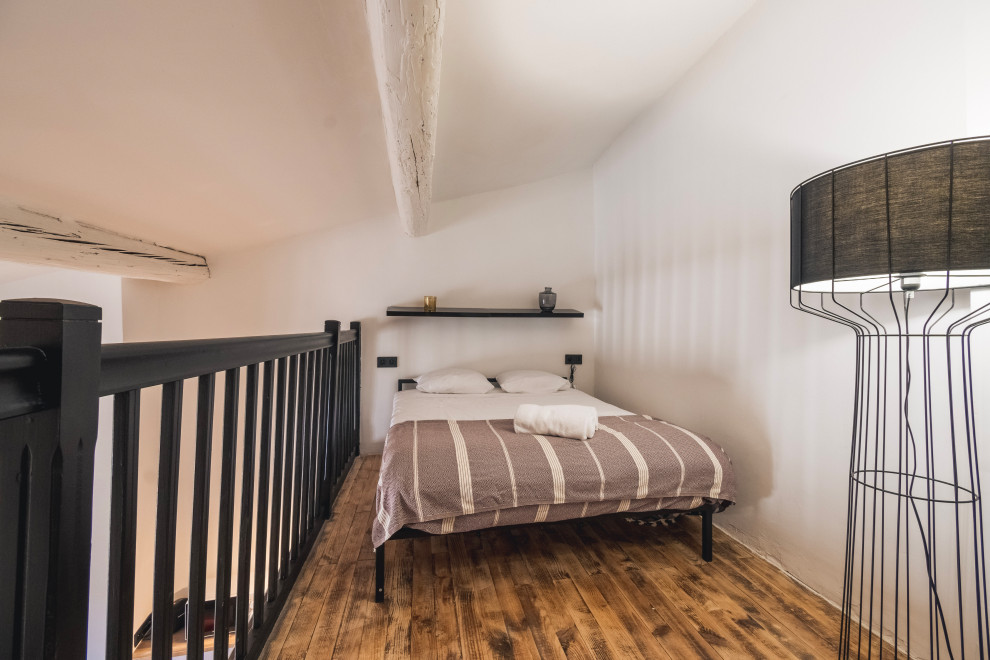 Idéer för ett litet modernt sovloft, med vita väggar och brunt golv