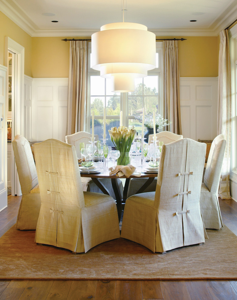 This is an example of a traditional dining room in Portland with yellow walls and dark hardwood floors.