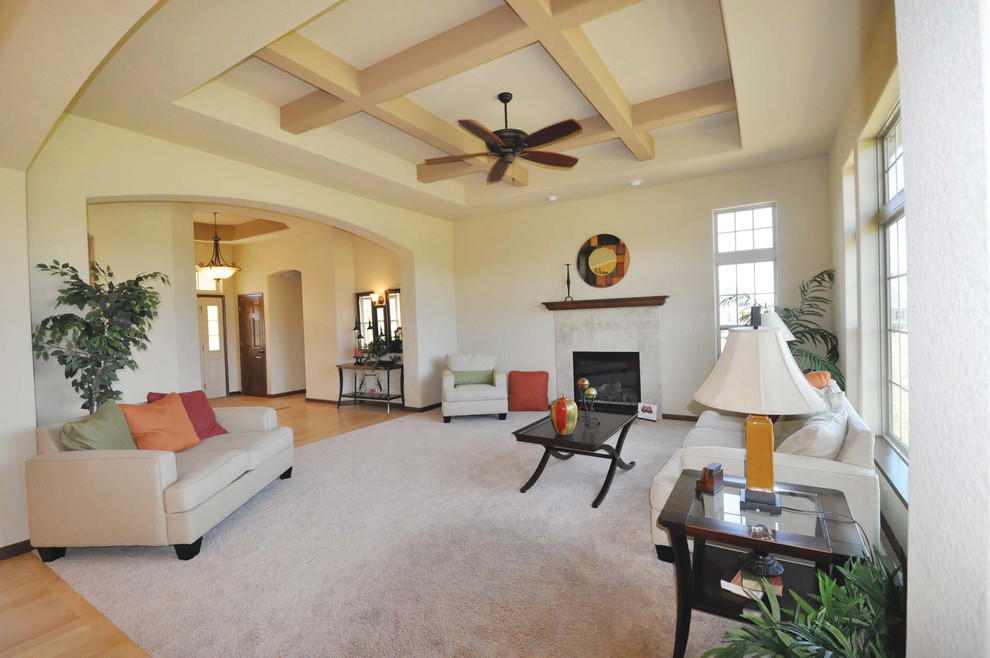 This is an example of a mid-sized traditional open concept living room in Milwaukee with beige walls, carpet, a standard fireplace and a tile fireplace surround.
