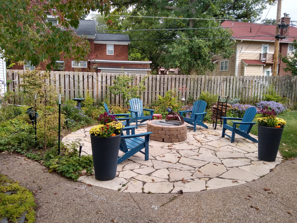 Photo of a mid-sized country front yard patio in Cedar Rapids with a fire feature, natural stone pavers and a pergola.