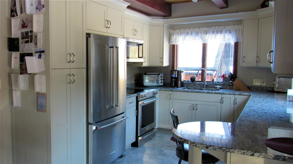 Inspiration for a mid-sized transitional u-shaped eat-in kitchen remodel in Boston with an undermount sink, shaker cabinets, beige cabinets, granite countertops, stainless steel appliances, a peninsula and gray countertops