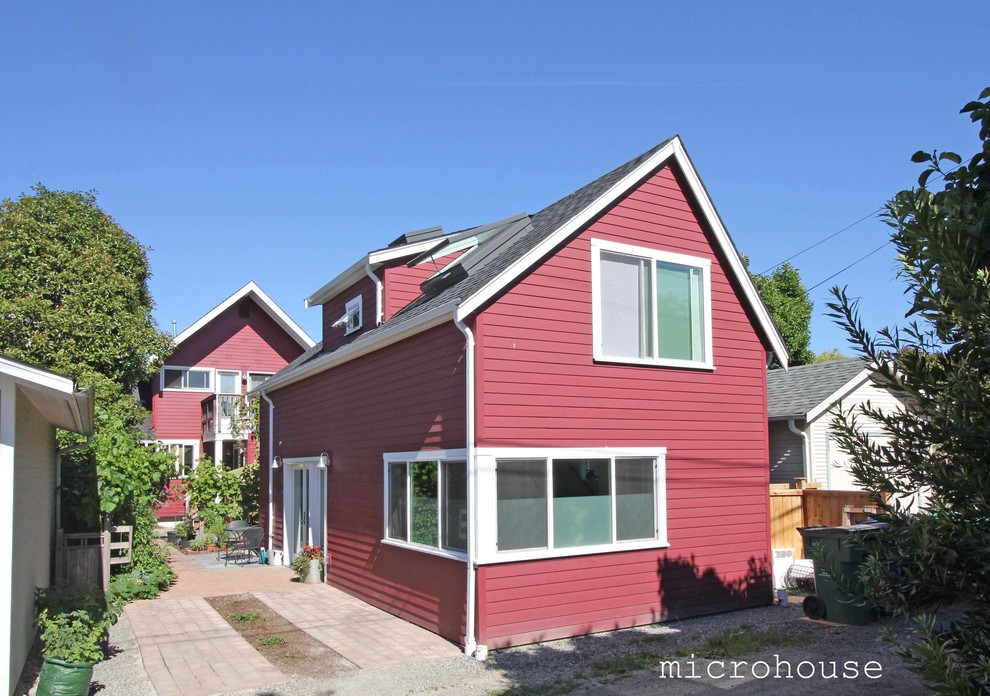 Design ideas for a small contemporary two-storey red exterior in Seattle with concrete fiberboard siding and a gable roof.