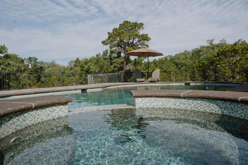 Photo of an expansive country backyard custom-shaped aboveground pool in Austin with a hot tub and tile.
