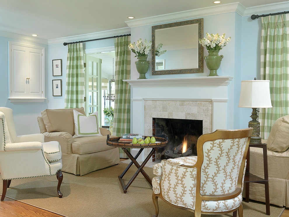 This is an example of a mid-sized traditional formal enclosed living room in Other with blue walls, light hardwood floors, a standard fireplace, a stone fireplace surround and a concealed tv.