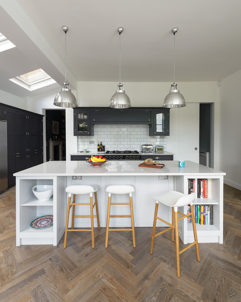 Inspiration for a mid-sized traditional eat-in kitchen in London with shaker cabinets, dark wood cabinets, quartzite benchtops and with island.